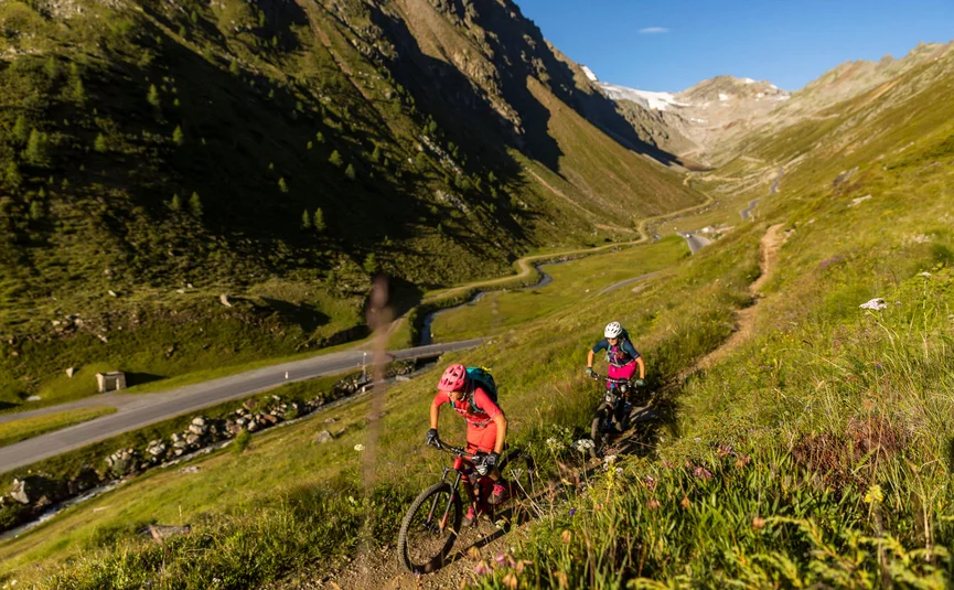 Zwei Frauen fahren Mountainbike auf Bergweg im Sommer