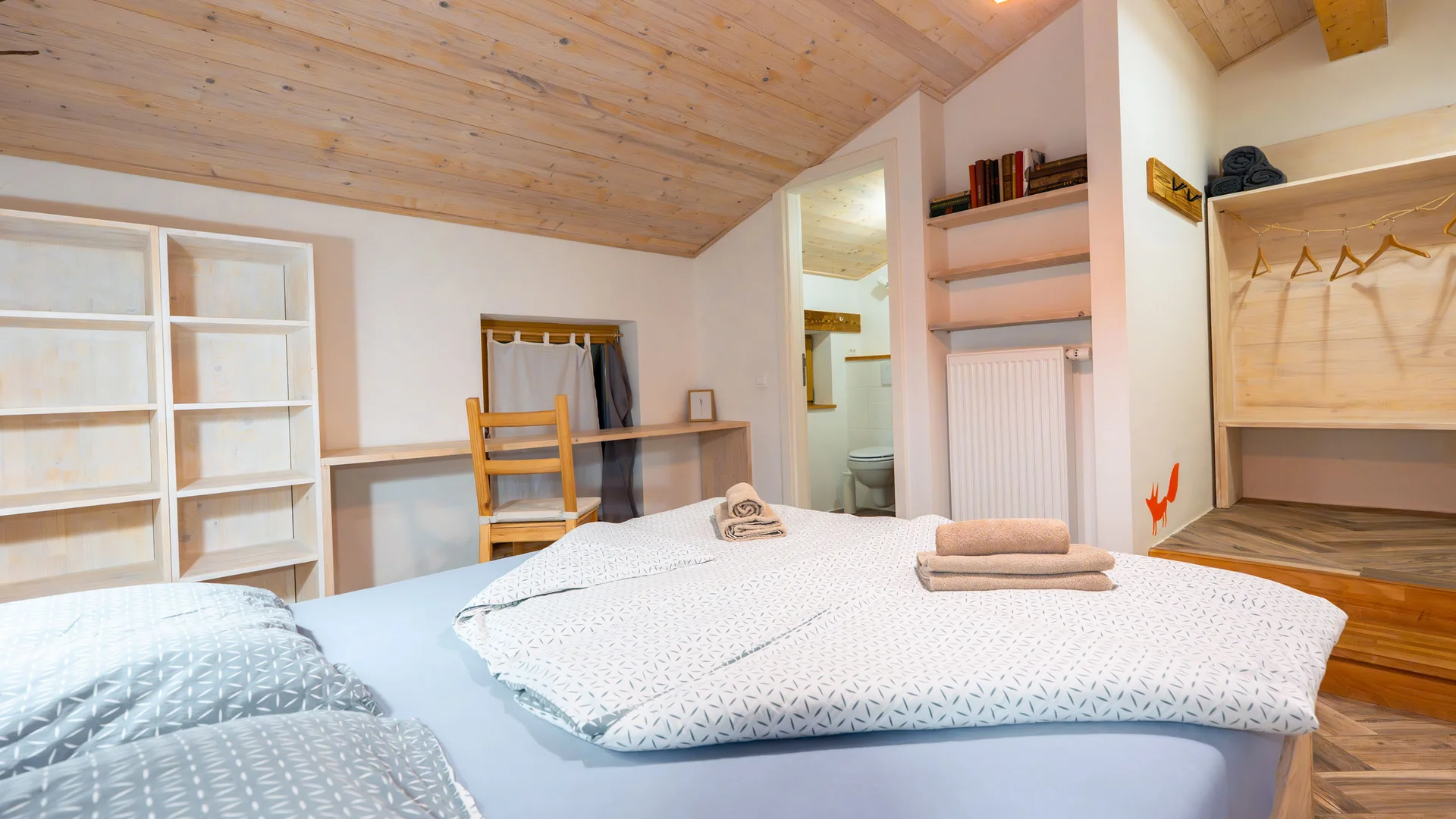 Modernes Schlafzimmer mit Holzdach, Bett und offener Kleiderablage