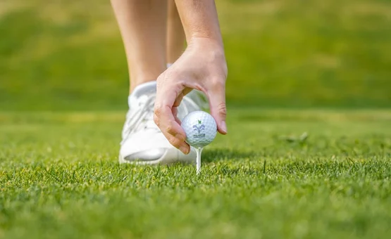 Golf Unlimited 4 days Hand placing golf ball on tee on green golf course