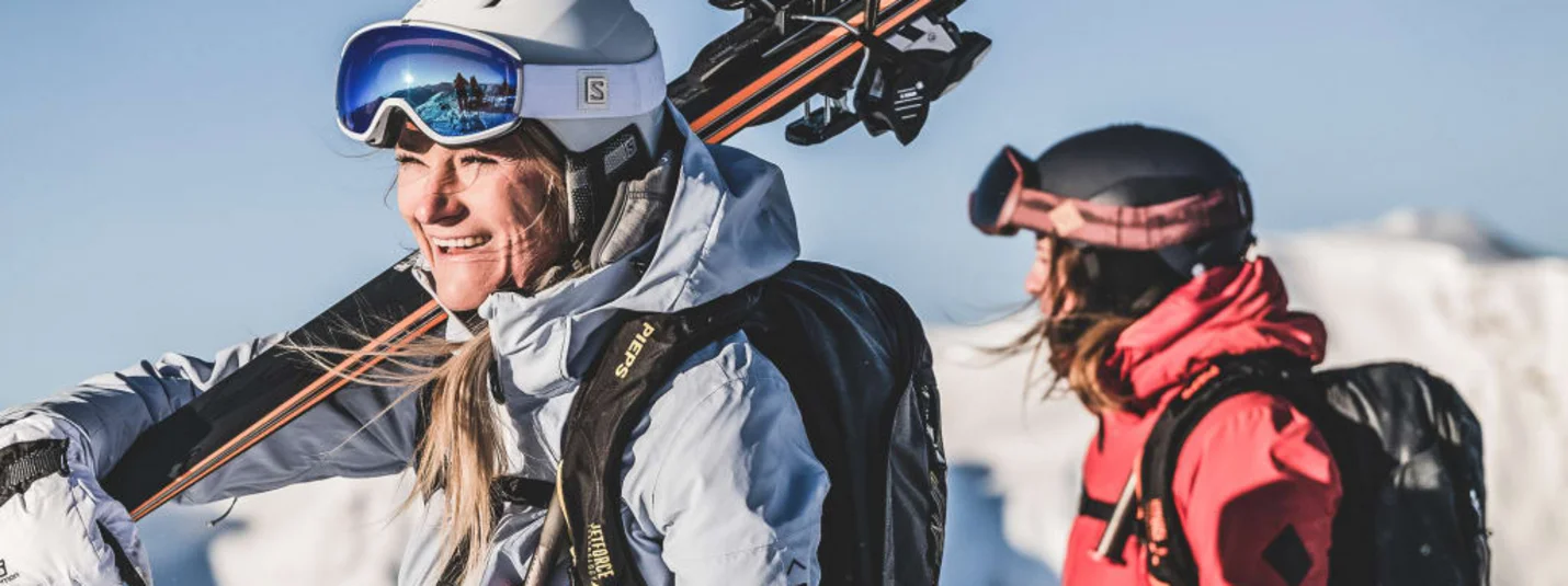Twee skiërs in winterkleding met uitrusting voor besneeuwde bergen