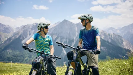 Zwei Mountainbiker im Berggebiet, die sich unterhalten und lachen
