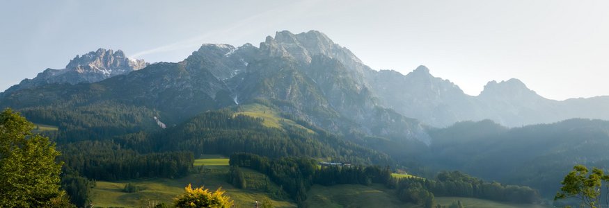 Puradies © creatingclick Person entspannt im Pool mit Blick auf bewaldete Berge und grüne Wiesen