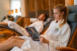 Mountain-Lake experience / 3 nights Woman in bathrobe reading a magazine while relaxing on a spa chair