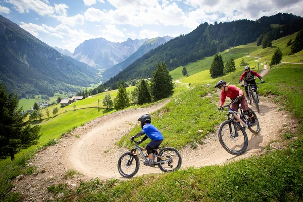 Best of Brandnertal © Michael Marte - Bikepark Brandnertal Three mountain bikers riding on a mountain trail in the Alps
