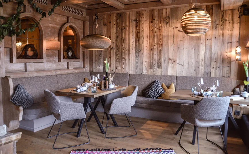 Gemütlicher Essbereich mit Holzwänden und stilvollen Sitzmöbeln