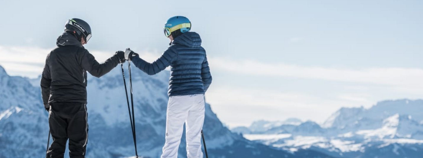 Dolomiti Super Première 4=3 Twee skiërs tikken skistokken aan voor besneeuwde bergen