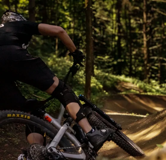 Mountainbiker fährt auf schlammigem Waldweg im Bikepark Bovec