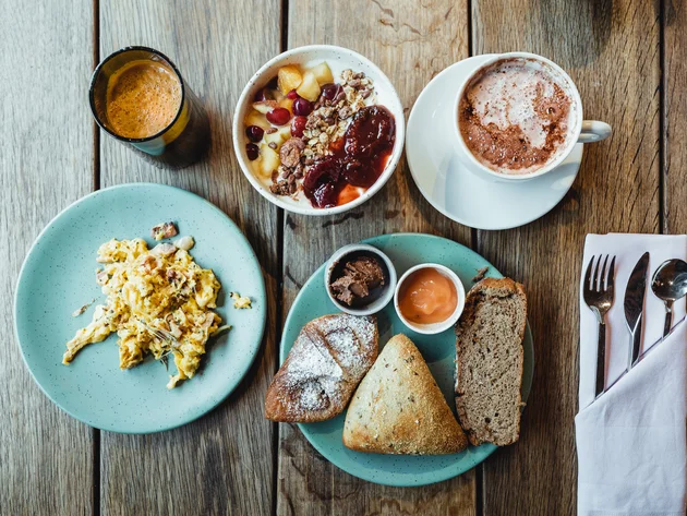 Best of Brandnertal © Manuel Dietrich Frühstück mit Rührei, Brot, Müsli, Kaffee und Orangensaft auf Holztisch