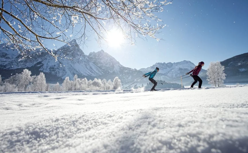 Langlauf Short Stay 4 Tage 2026-27 Zwei Personen beim Langlaufen in sonniger, verschneiter Berglandschaft