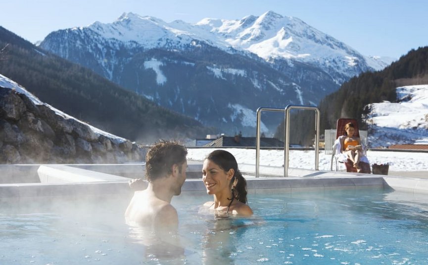 Relax und Aktiv Tage Koppel in verwarmd zwembad met besneeuwde bergen op de achtergrond