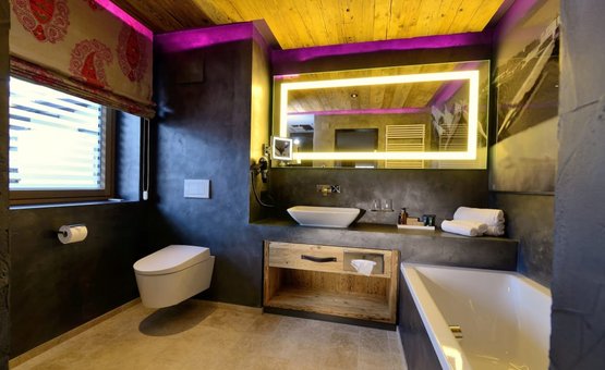 SKI + LOVE Modern bathroom with illuminated mirror and wooden ceiling