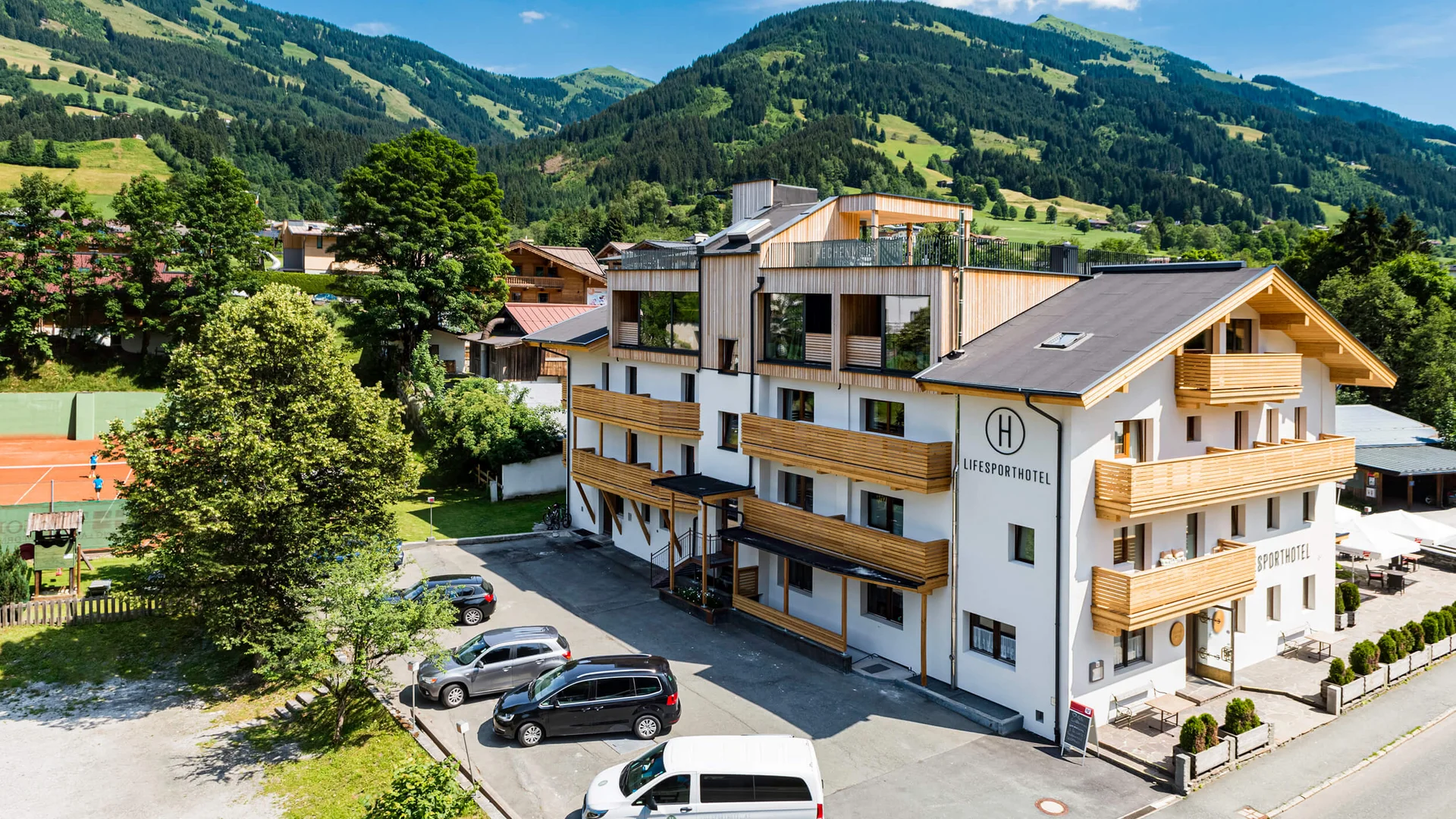 Modernes Hotelgebäude mit Bergen im Hintergrund an einem sonnigen Tag