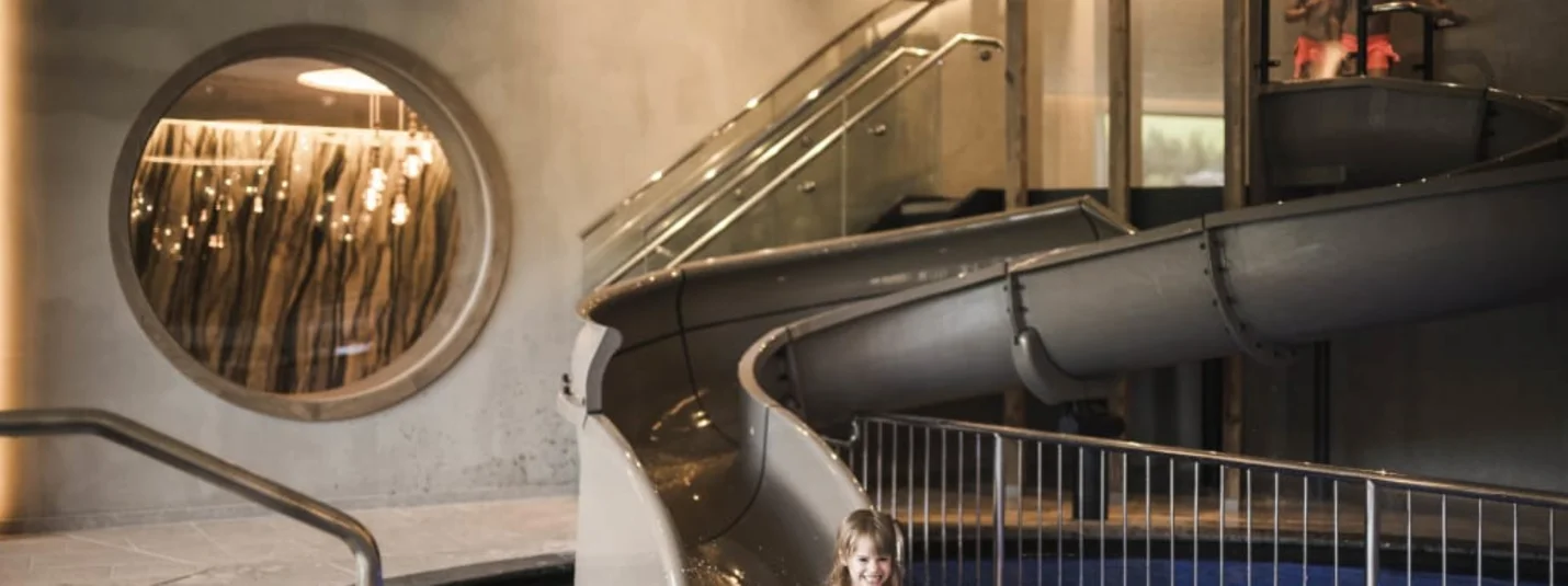 Excelsior Family Weeks Kind speelt in binnenzwembad met glijbaan en water