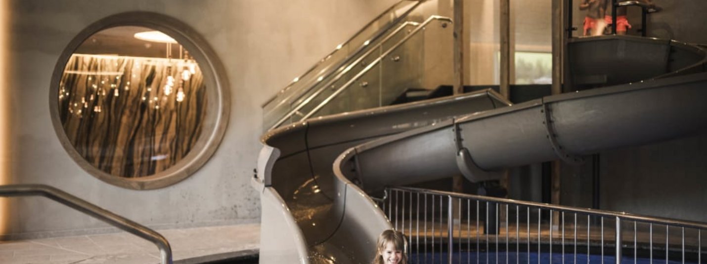 Excelsior Family Weeks Kind speelt in binnenzwembad met glijbaan en water