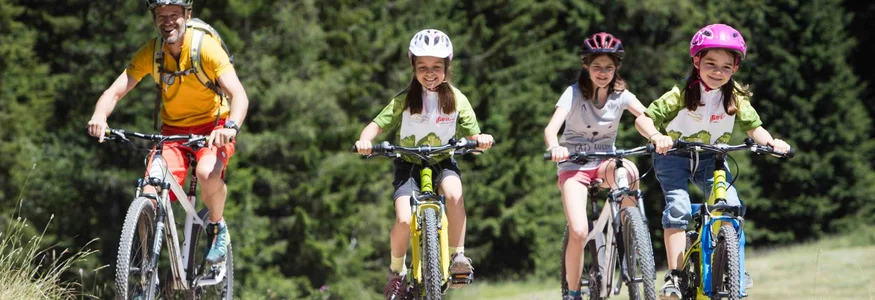 BEST OF Familien-Bikeurlaub © Exploring GmbH Vater und drei Kinder fahren mit Fahrrädern auf einem Waldweg