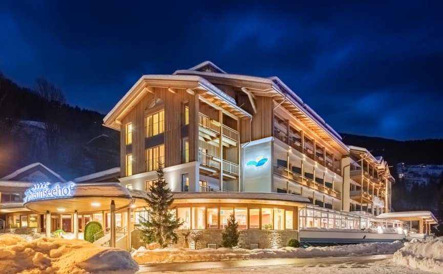 Illuminated hotel at night in winter with snow and mountains