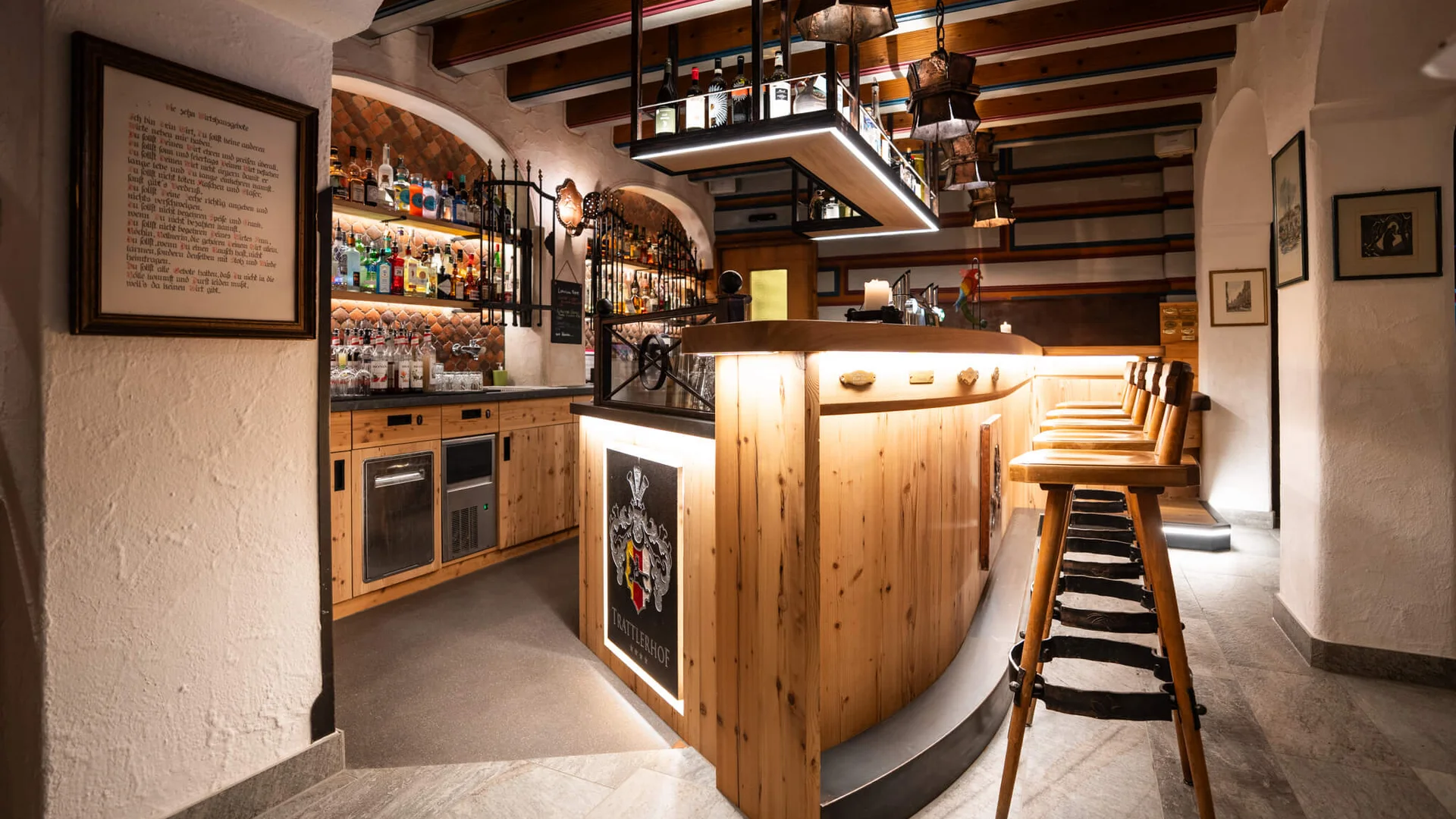 Gemütliche Bar mit Holztheke, Barhockern und Flaschenregalen an der Wand
