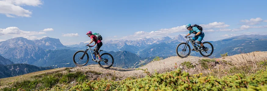 Zwei Mountainbiker fahren auf einem Bergweg in den Alpen