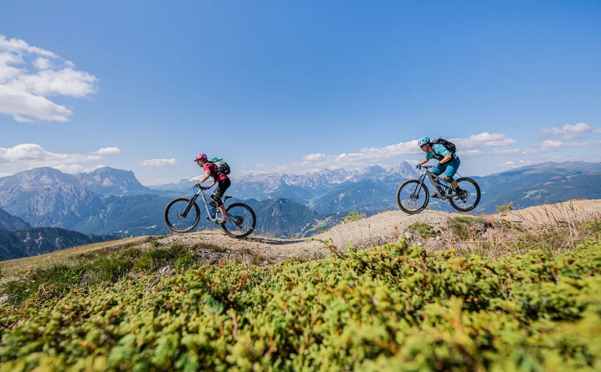 Zwei Mountainbiker fahren auf einem Bergweg in den Alpen