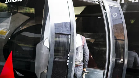 Person schiebt Mountainbike in eine Gondel der Seilbahn Livigno