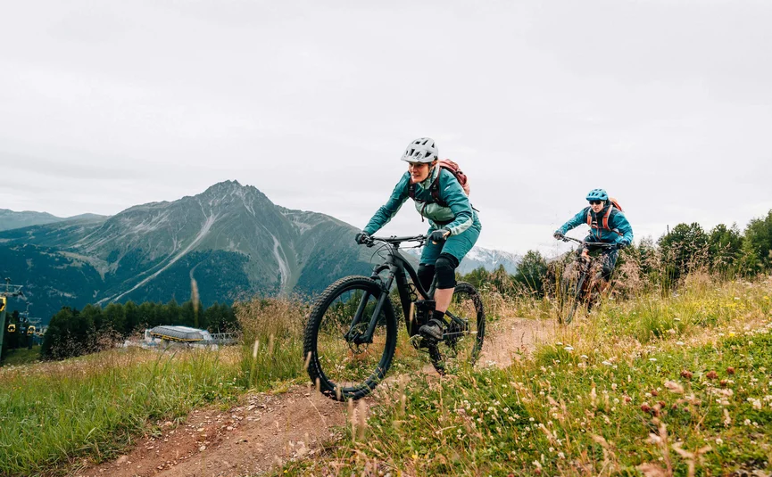 Twee mountainbikers op een grasachtig bergpad