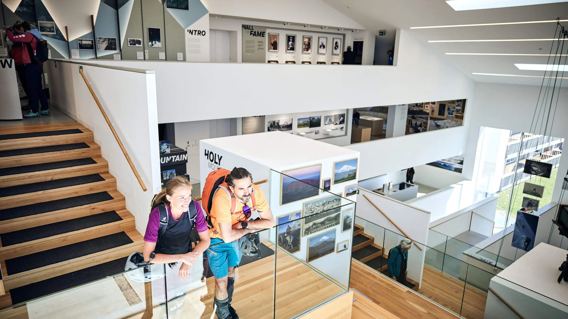 Besucher in moderner Galerie mit Fotos und Treppen