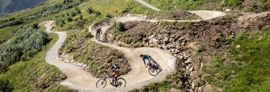 Ein perfektes Bike-Wochenende in Ischgl © TVB Ischgl-Paznaun Mountainbiker fahren einen kurvigen Weg in den Alpen hinab