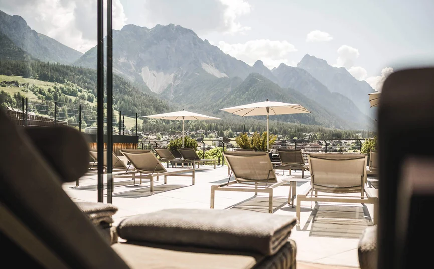 Sun terrace with lounge chairs and mountain view in the background