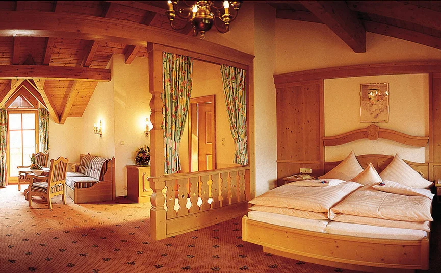 Cozy hotel room with wooden furniture and bed under sloped ceiling