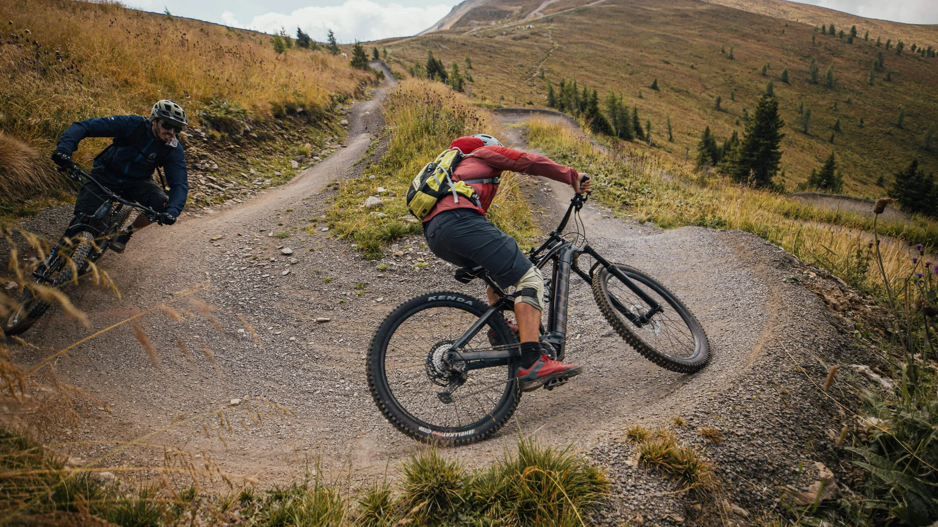 Zwei Mountainbiker fahren auf einem kurvigen Bergweg