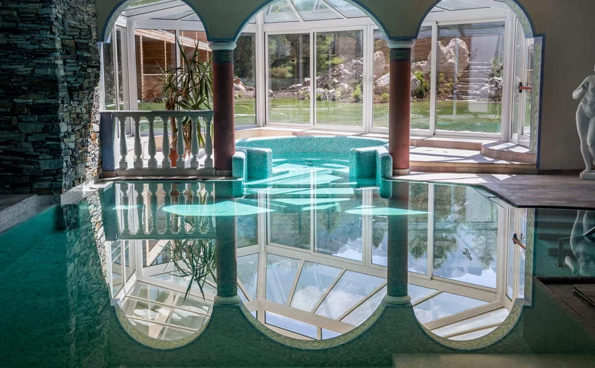 Indoor pool with three arches and garden view