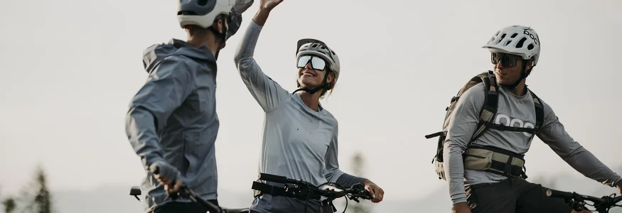 Bye bye Tauernhof, hello Dips&Drops! Drei Fahrradfahrer in Helmen geben sich Highfive im Freien