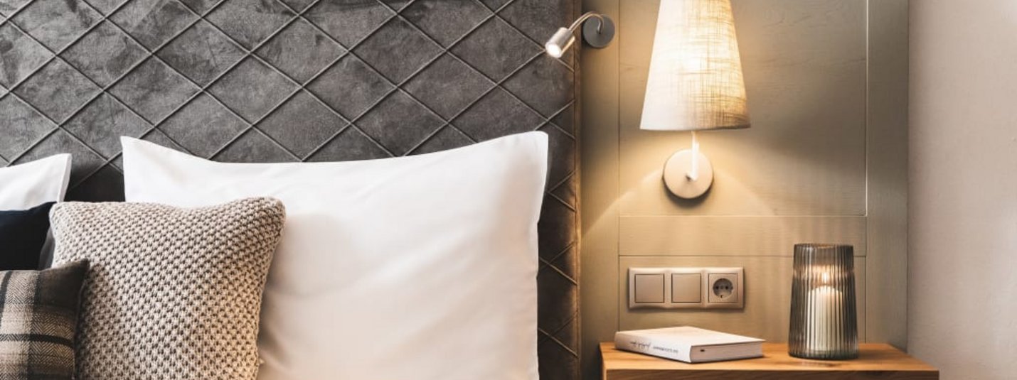 Modern bedroom with decorative headboard and bedside lamp