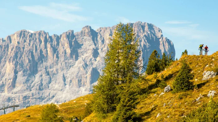Zwei Radfahrer auf Bergpfad mit Felsmassiv im Hintergrund