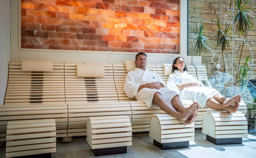 Mann und Frau in Bademänteln entspannen sich in einer modernen Sauna