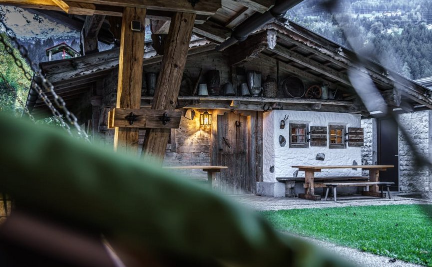 Cozy wooden cabin with table and benches in a mountainous area