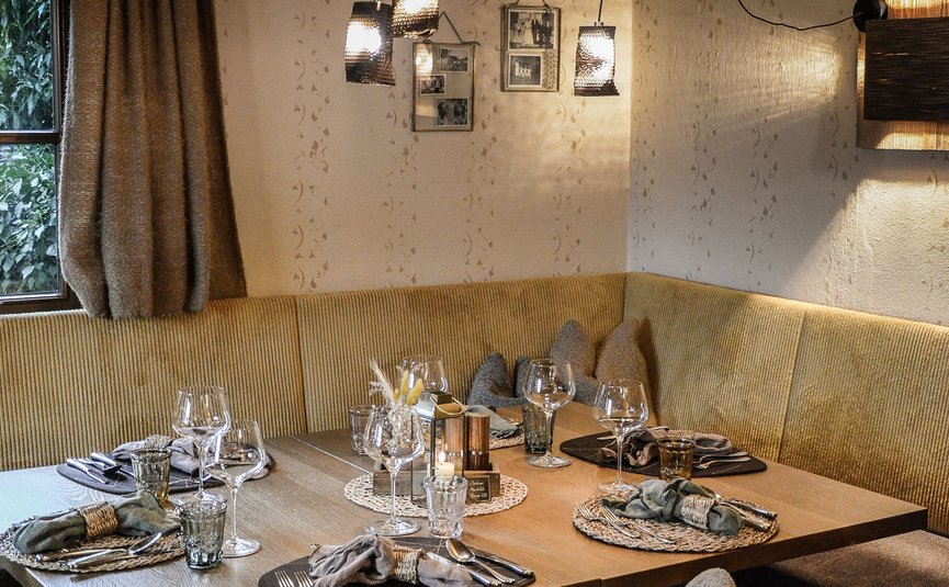 Gemütlicher Essbereich mit auffälliger Beleuchtung und gedecktem Holztisch