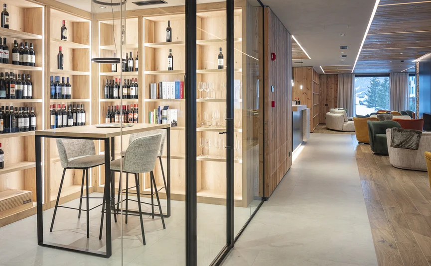Moderner Weinraum mit Lichtregalen und Sitzbereich im Hotel