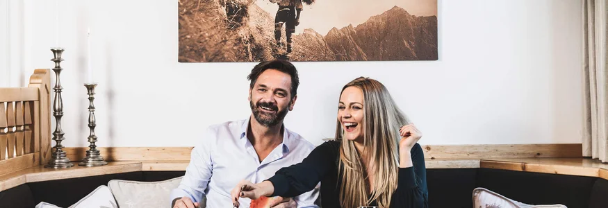 Paar genießt Frühstück mit verschiedenen Speisen an einem Holztisch