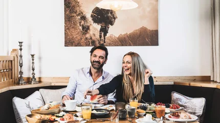 Biken & Genießen im Montanara © Anja Koppitsch Photography Paar genießt Frühstück mit verschiedenen Speisen an einem Holztisch