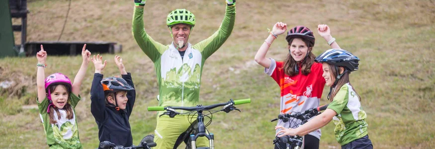 Radfahrergruppe mit Kindern und Erwachsenen feiert im Freien mit Fahrrädern