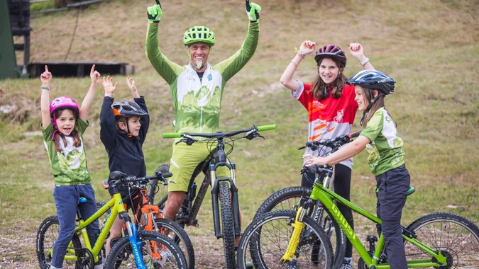 Radfahrergruppe mit Kindern und Erwachsenen feiert im Freien mit Fahrrädern