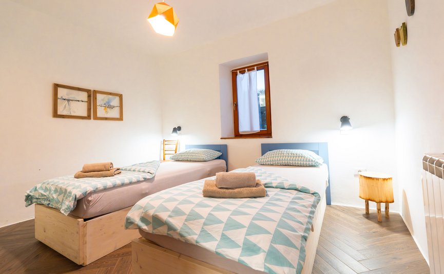 Simple bedroom with two single beds and patterned bedding