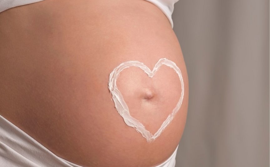 Babymoon Zwangere buik met hartje van crème erop