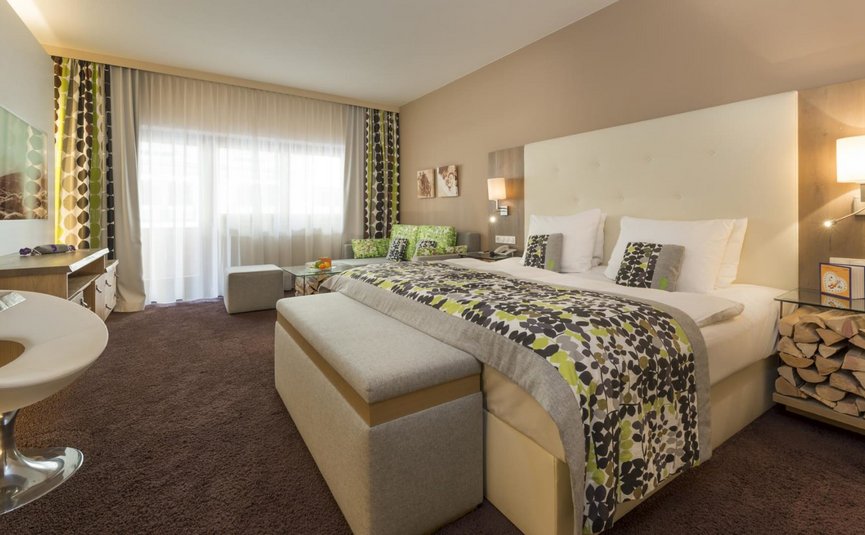 Gezellige hotelkamer met tweepersoonsbed, bank en moderne inrichting