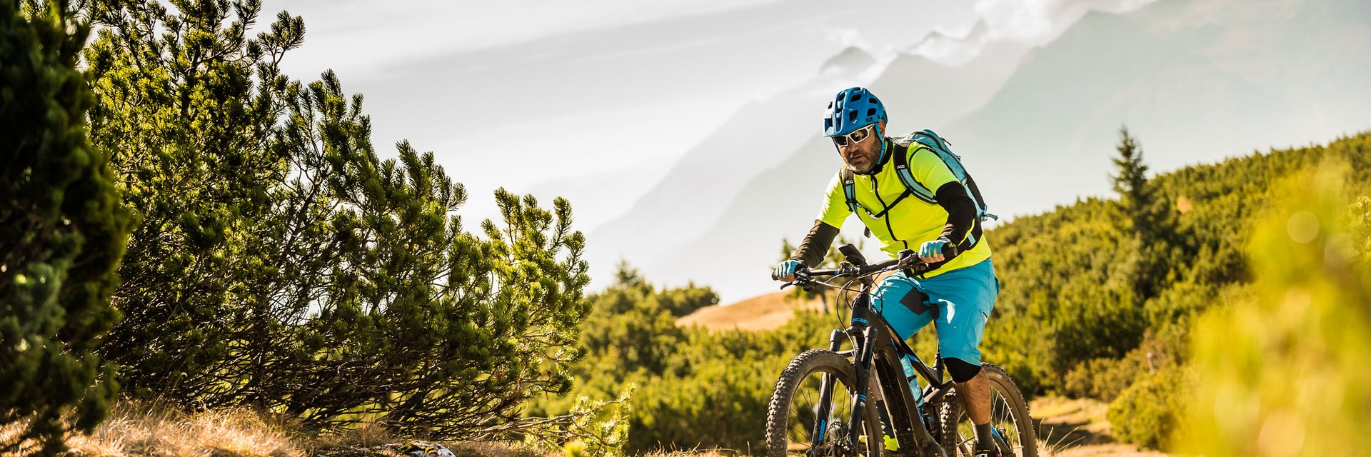 Traminerhof | good life. cool ride. © TV Tramin - Antie Braito Man mountainbiken op een pad met bergen op de achtergrond