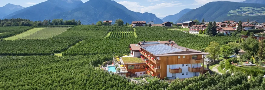 bike festa Südtirol in Brixen © Hannes Niederkofler Hotel mit Solarpanelen inmitten von Obstplantagen vor Bergkulisse