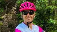 Frau mit Helm neben Mountainbike auf Waldweg