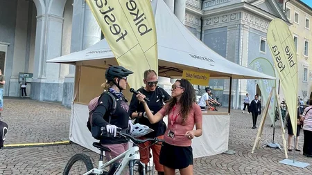 Das war die bike festa Südtirol in Brixen © Max Messner - Interview auf der bike festa Südtirol 2026 Mountainbiker mit Fahrrad spricht mit einer Frau vor einem historischen Gebäude mit Eventzelt
