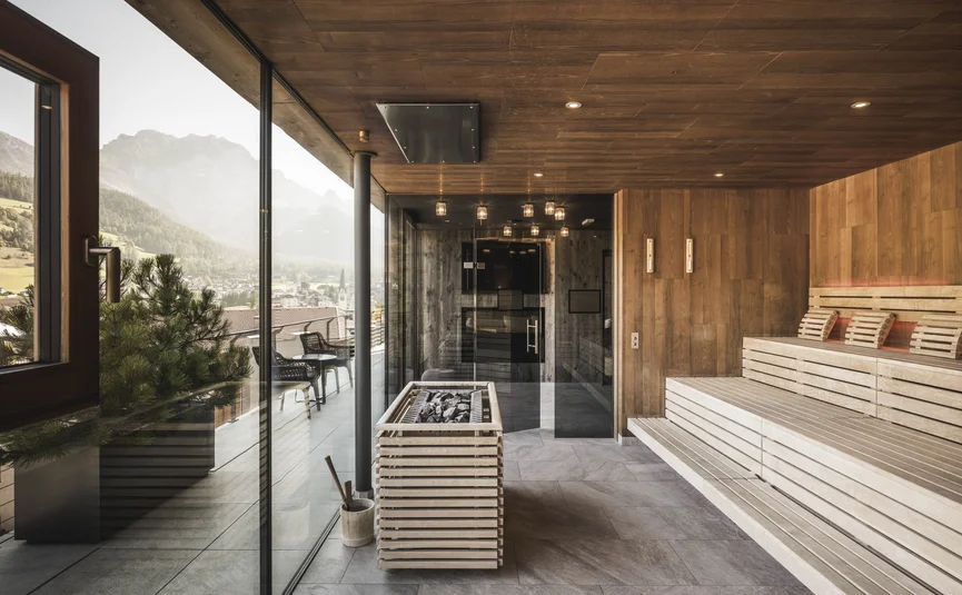 Modern sauna with wood paneling and mountain view through large windows
